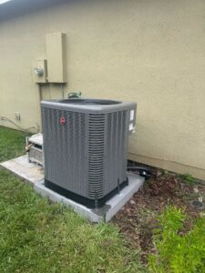 A newly installed outdoor HVAC condenser unit next to a building by QUICK AIR USA in Orlando, FL.