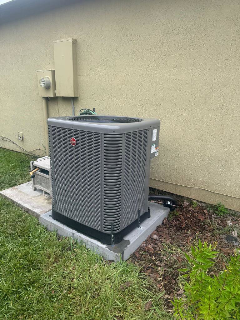 A newly installed outdoor HVAC condenser unit next to a building by QUICK AIR USA in Orlando, FL.