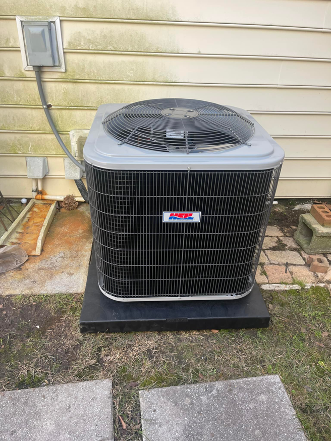 A newly installed outdoor HVAC condenser unit on a black pad by Wicked Cool HVAC in Charleston, SC.