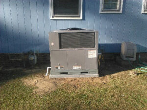 A newly installed outdoor HVAC unit next to a blue residential house by NAS Heating & Air in Fayetteville, NC.