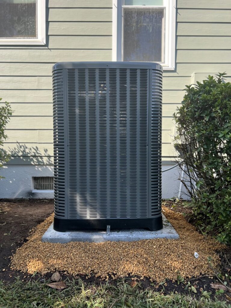 A newly installed outdoor HVAC unit by Brand Air Heating and Cooling LLC on a gravel pad in Wilmington, NC.