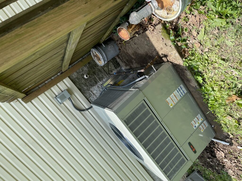 A newly installed outdoor HVAC condenser unit next to a residential building by Gouker's Best Air in Franklin, TN.