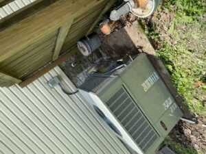 A newly installed outdoor HVAC condenser unit next to a residential building by Gouker's Best Air in Franklin, TN.