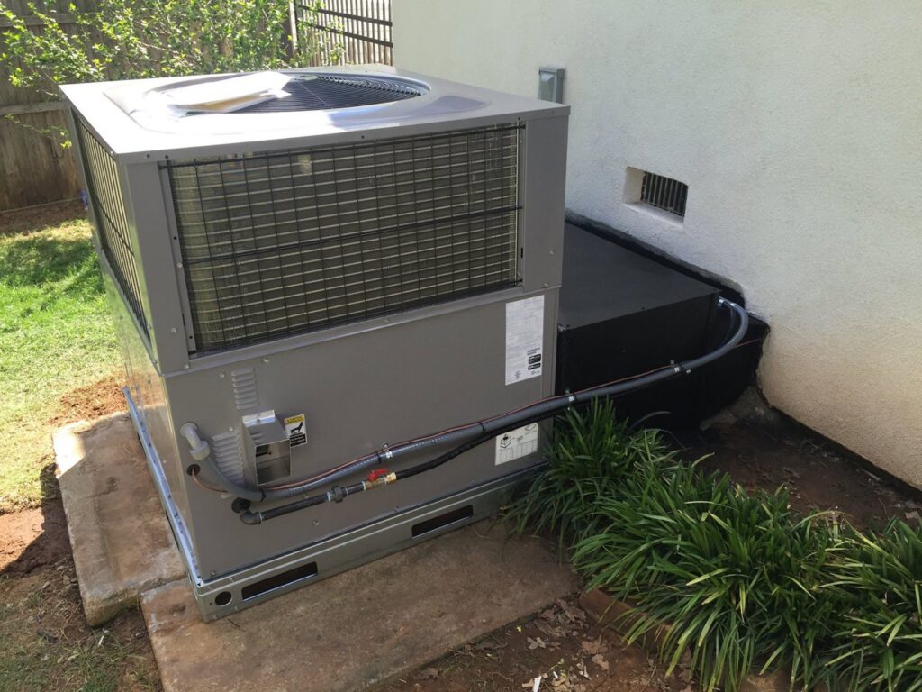 A newly installed outdoor HVAC unit with connected piping and electrical by Prudhom Mechanical LLC in Edmond, OK