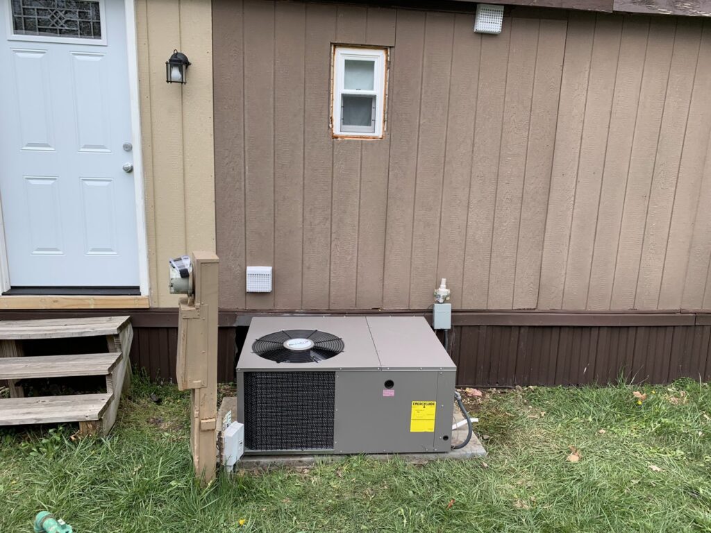 A new outdoor HVAC unit installed next to a residential building by PureAir HVAC in Bel Air, MD.