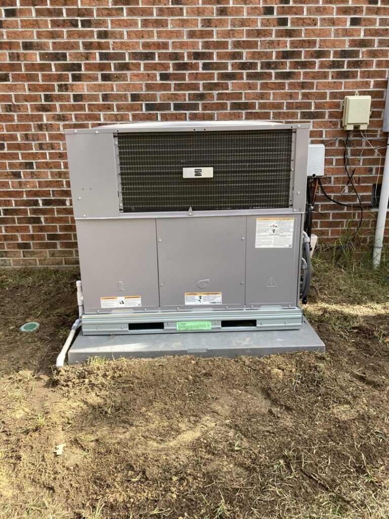 A new outdoor HVAC unit professionally installed next to a brick building by Your Angel Heating And Cooling LLC in Cary, NC.
