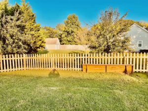 A newly installed wooden picket fence enclosing a backyard by Preston's Fencing and Decks LLC in Murfreesboro, TN.