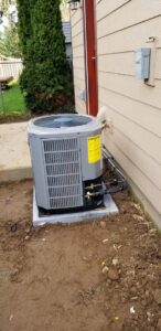 A new residential air conditioning unit installed on a concrete pad by Excellence Heating & Cooling, LLC. in Beaverton, OR.