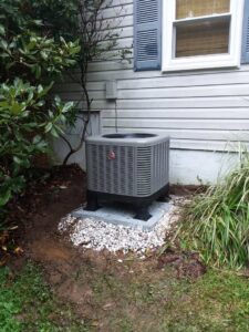 A newly installed Rheem outdoor HVAC condenser unit next to a residential home by Appliance Doctor, Inc. in Annapolis, MD.