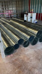 A stack of new round metal HVAC ducts ready for installation by Big Leaf Mechanical LLC in South Salt Lake, UT.