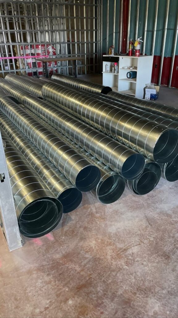 A stack of new round metal HVAC ducts ready for installation by Big Leaf Mechanical LLC in South Salt Lake, UT.