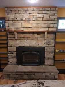 A newly installed stone fireplace with a modern insert by Centerville Pipestone Chimney Services LLC in Dayton, OH.