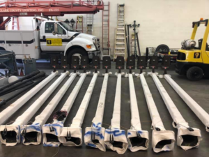 New street light poles staged for installation with a service truck from Desert Clark County Lighting in Las Vegas, NV.
