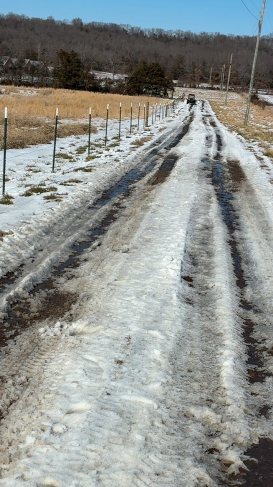 New T-post fence installation along a snowy dirt road by Stronghold Fence and Construction in Springdale, AR.