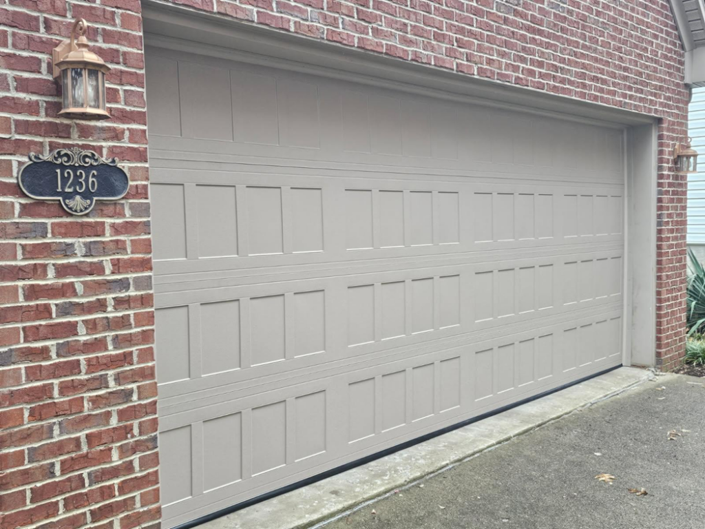 A newly installed tan garage door on a brick home by Door-Tech LLC in Lexington, KY.
