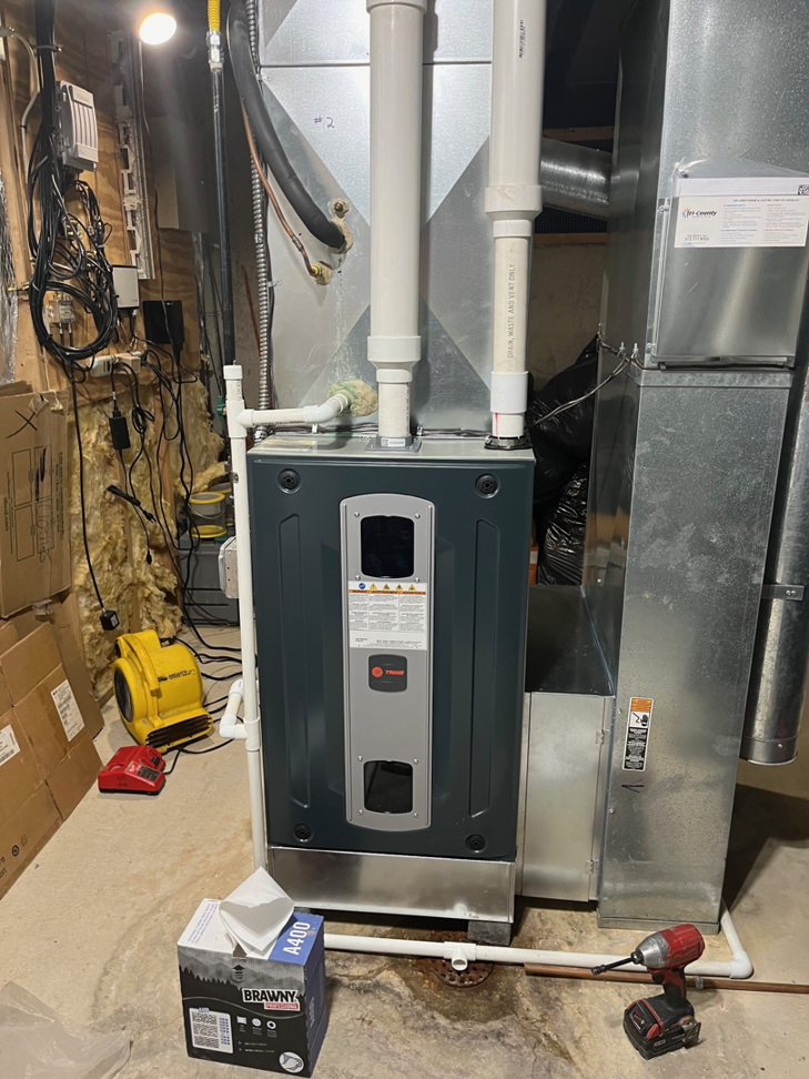 A newly installed Trane furnace and ductwork in a utility area by Tri County Heating and Cooling in Longmont, CO.