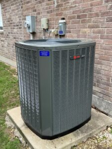 A newly installed Trane outdoor AC unit next to a brick wall by Fort Worth Air Conditioning Co. Inc. in Fort Worth, TX.