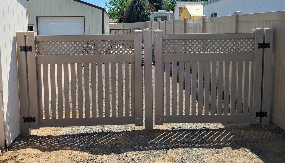A newly installed light brown vinyl double gate with a lattice top by Big Canyon Fencing in Lewiston, ID.