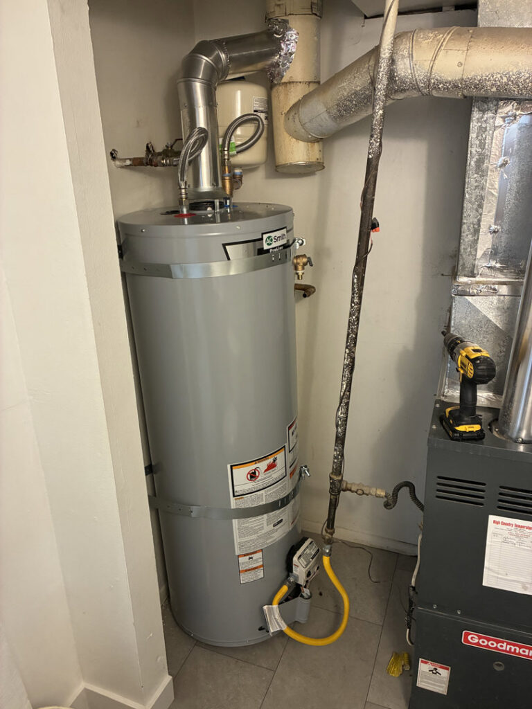 A newly installed water heater next to a furnace, showcasing plumbing and HVAC services by Diamond L Plumbing & HVAC in Salt Lake City, UT.