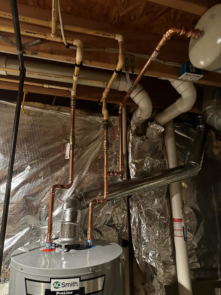 Close-up of a newly installed water heater with copper and PVC piping by Adonis Hvac in Annapolis, MD.