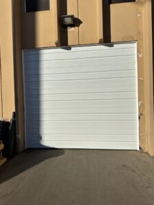 A newly installed white commercial garage door by Strongdoor garage in Denver, CO.
