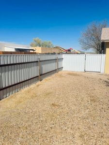 A long stretch of newly installed white corrugated metal fence by Pecos Construction and Fencing, LLC in Roswell, NM.