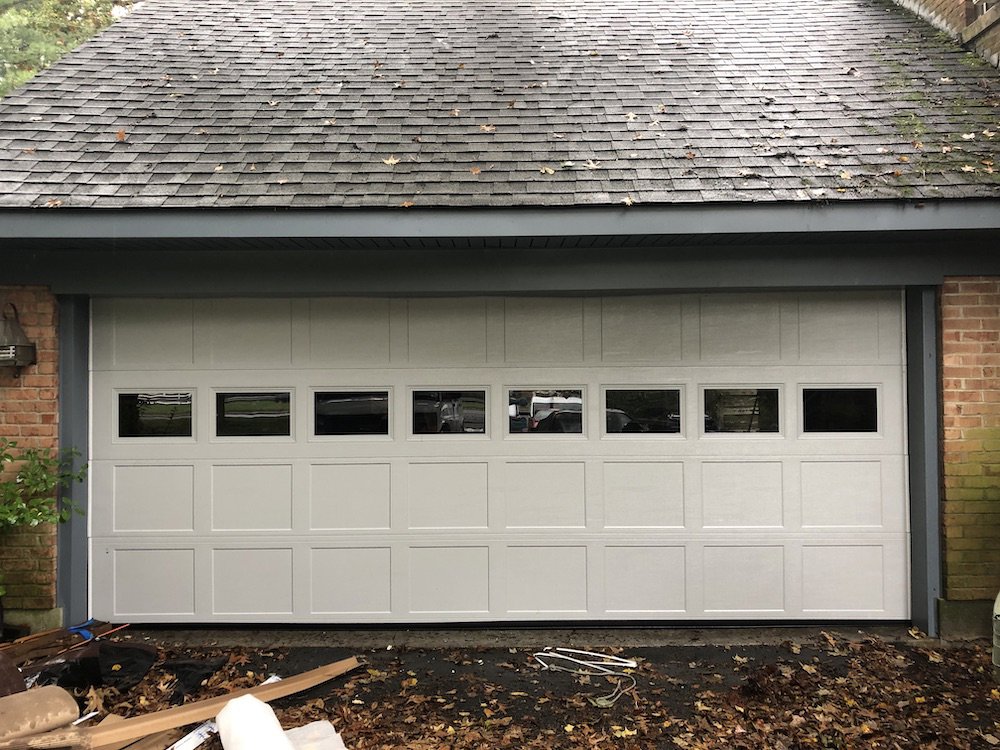 A newly installed white garage door with small windows, showcasing a completed project by Door-Tech LLC in Lexington, KY.
