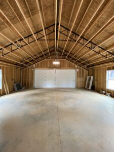 A newly installed white garage door inside a garage under construction by Foothills Garage Door Service LLC in Louisville, TN.