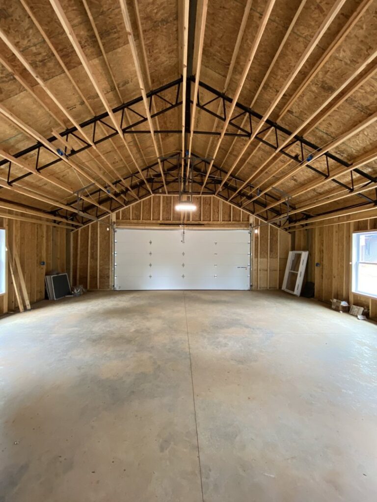 A newly installed white garage door inside a garage under construction by Foothills Garage Door Service LLC in Louisville, TN.