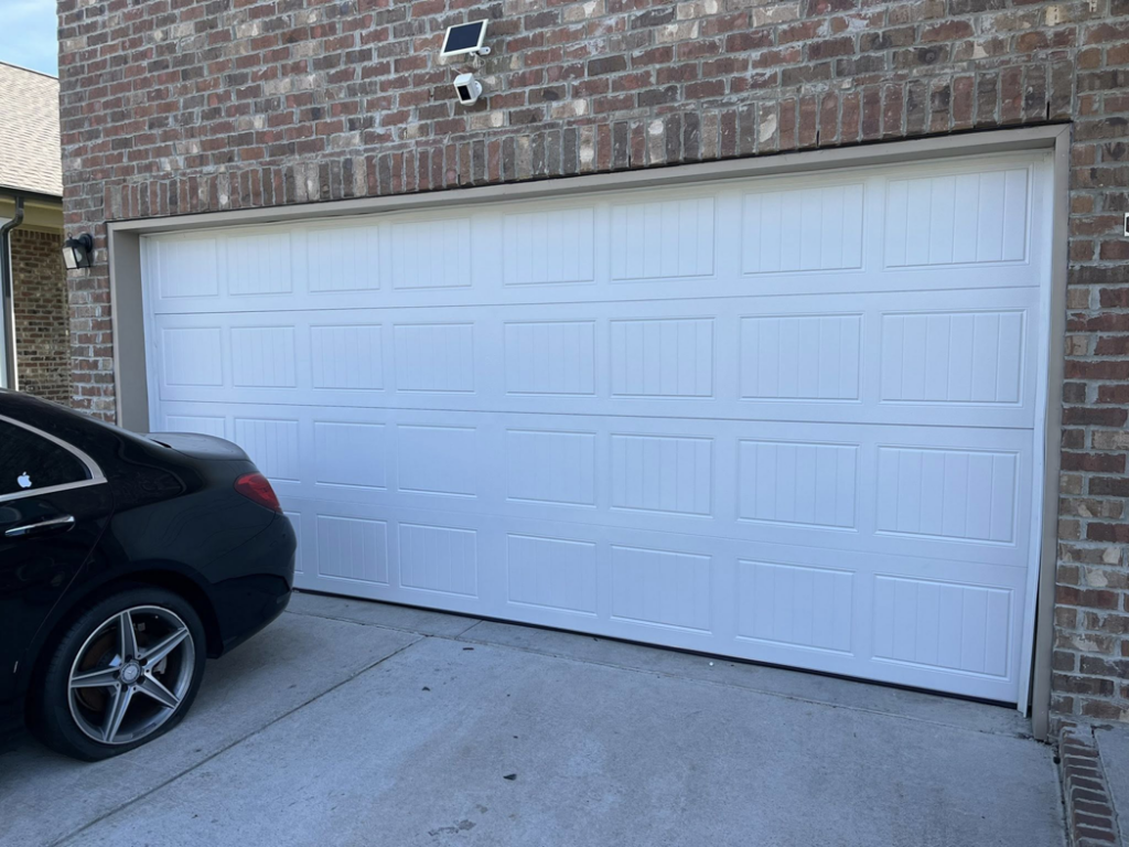 A newly installed white panel garage door on a brick home by J&S Garage Door Services in Franklin, TN.