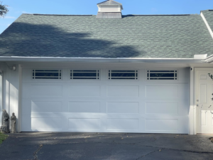 A newly installed white garage door with decorative windows by Taylor Overhead Door Co. in Dallas, TX