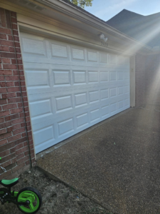 A newly installed white garage door on a brick home by The Garage Man in Memphis, TN.