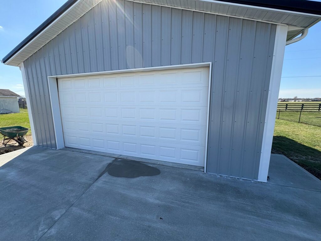 A newly installed white garage door on a metal building by Lenny's Garage Door in Louisville, KY.