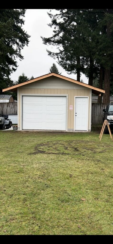A newly installed white garage door on a detached shed by Steadfast Garage Door Services LLC in Federal Way, WA.