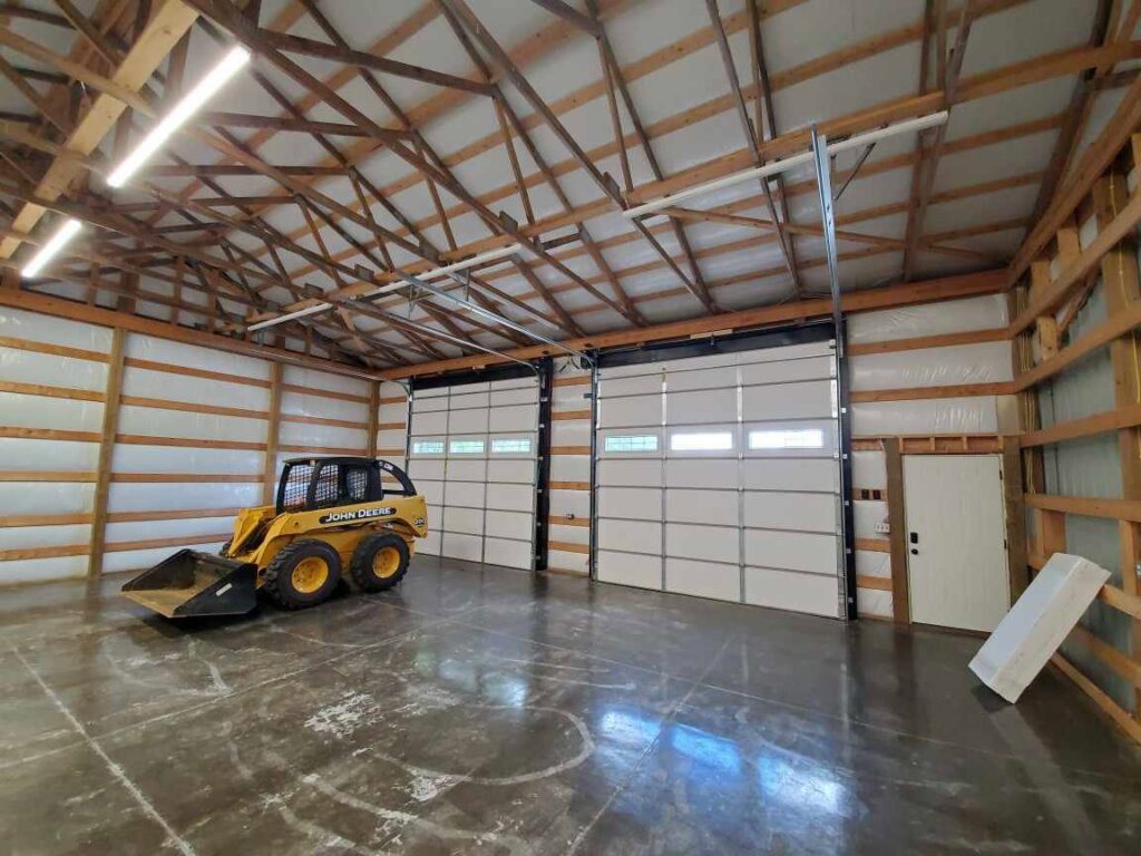 Two new white garage doors installed in a barn or workshop by Honest Overhead Garage Doors in Elizabethtown, KY.