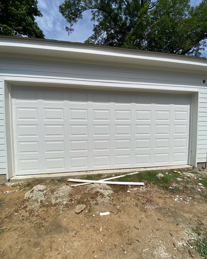 A newly installed white panel garage door on a residential property by J&C Bravo LLC in Cordova, TN.