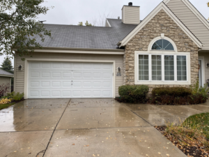 A newly installed white paneled garage door on a residential home by Geiszler Garage Door in Milwaukee, WI.