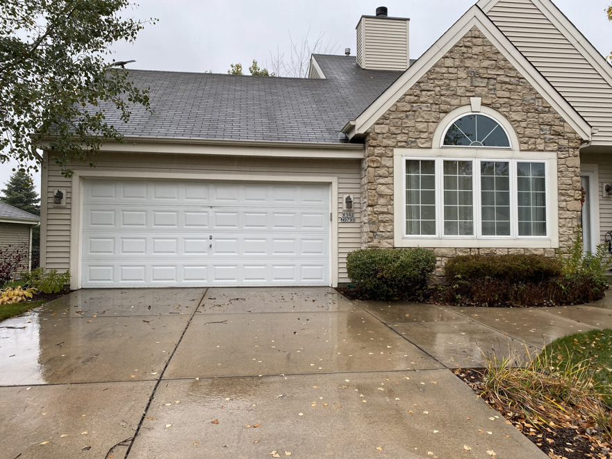 A newly installed white paneled garage door on a residential home by Geiszler Garage Door in Milwaukee, WI.