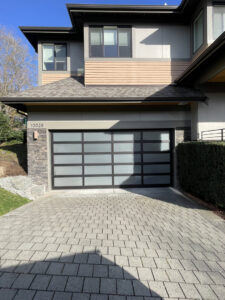 Two newly installed white residential garage doors on a large home by CHS Garage Repair of Seattle, WA.