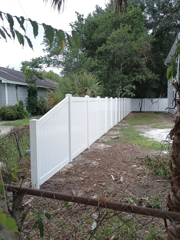 Newly installed white vinyl fence by Geo's Custom Fencing, LLC in Jacksonville, FL, replacing an old chain-link fence.