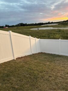 A newly installed white vinyl fence in a residential development, completed by Chesley Fence & Deck in Fairview Heights, IL.