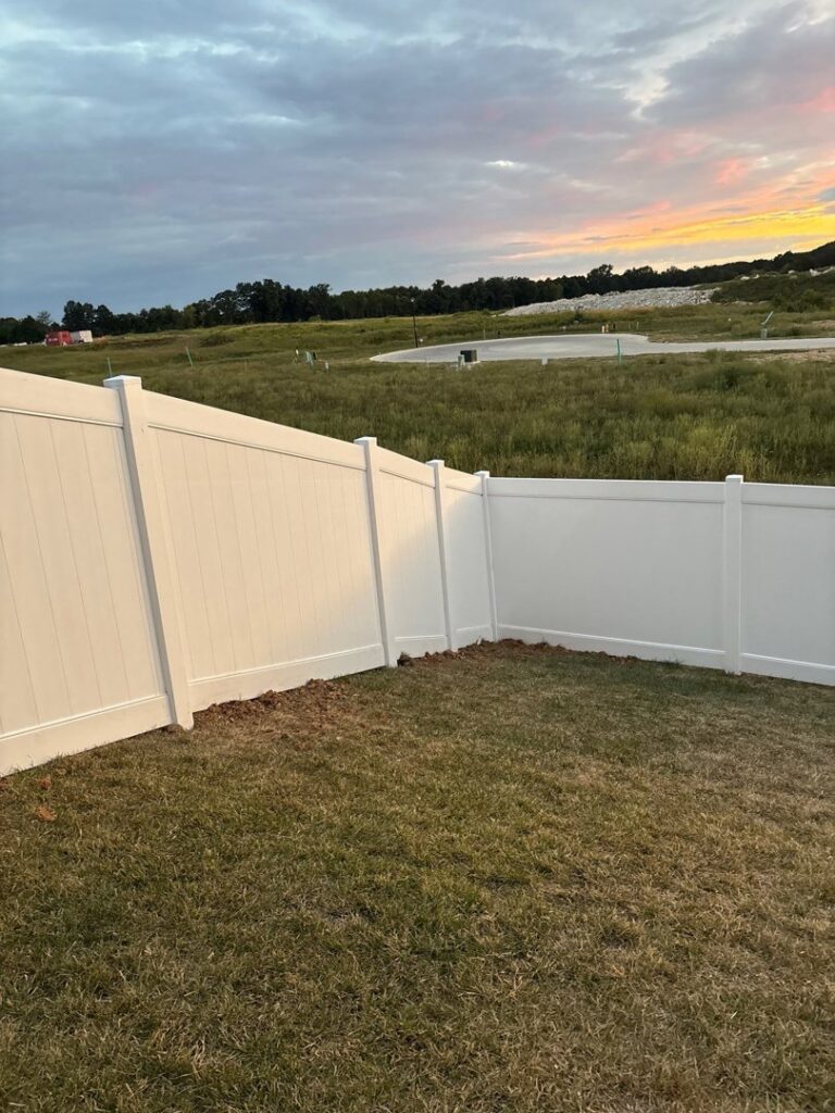 A newly installed white vinyl fence in a residential development, completed by Chesley Fence & Deck in Fairview Heights, IL.