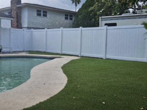A newly installed white vinyl fence surrounding a residential pool area by Geo's Custom Fencing, LLC in Jacksonville, FL.
