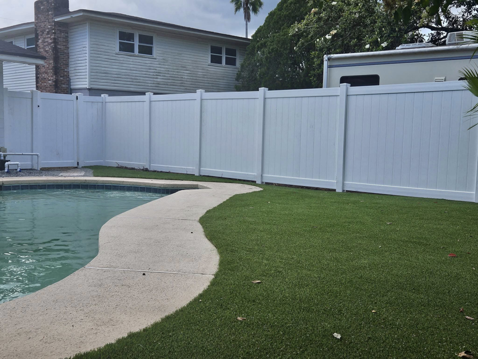 A newly installed white vinyl fence surrounding a residential pool area by Geo's Custom Fencing, LLC in Jacksonville, FL.