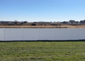 A new white vinyl privacy fence installed in a developing area by Rio Fence Co. in Lincoln, NE.
