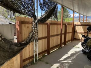 A newly installed wood privacy fence under a covered outdoor area by This And That Fence in Reno, NV.