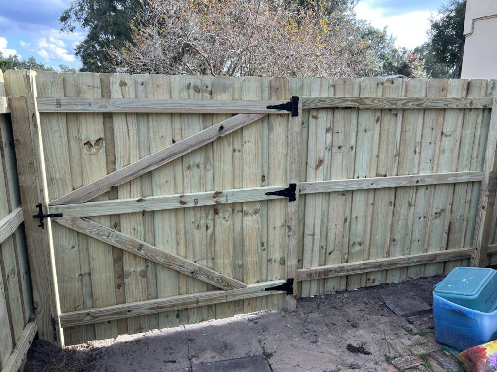 A newly installed wooden double gate for a fence by Florida Professional Fence LLC in Altamonte Springs, FL.
