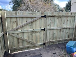 A newly installed wooden double gate for a fence by Florida Professional Fence LLC in Altamonte Springs, FL.