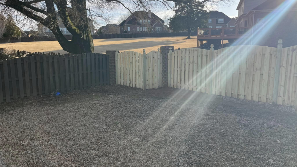 A newly installed light wood fence section by Precision Contracting LLC in Jupiter, FL, contrasting with an older fence.