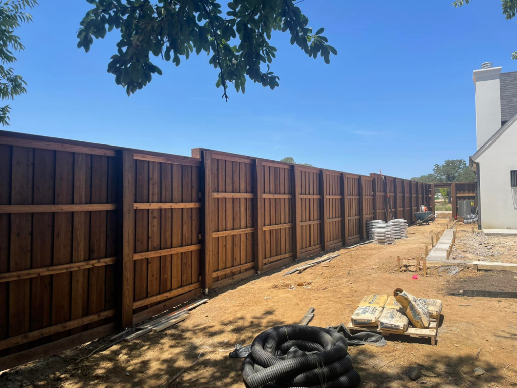 New wood fence installation with construction materials on site by 3M Custom Fence in Lewisville, TX.